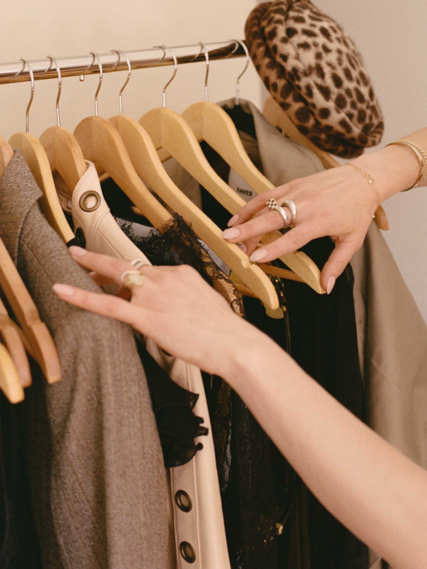 Hands browsing a clothing rack while shopping